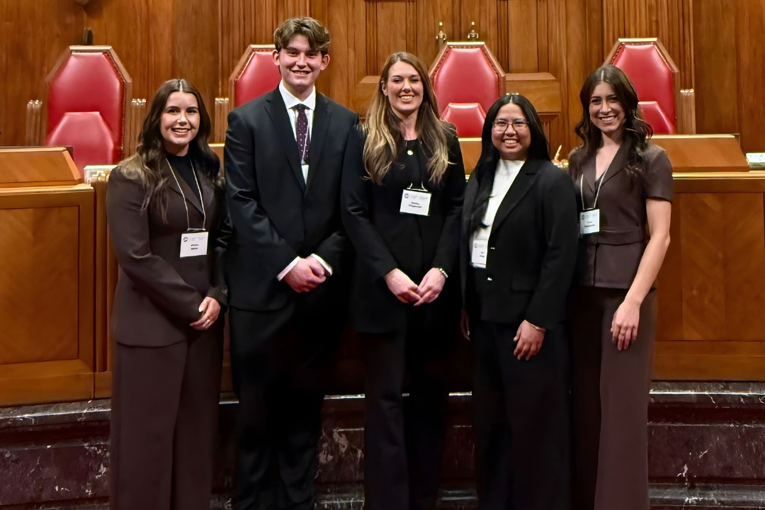 Men and women dressed in business attire posing for a group photo
